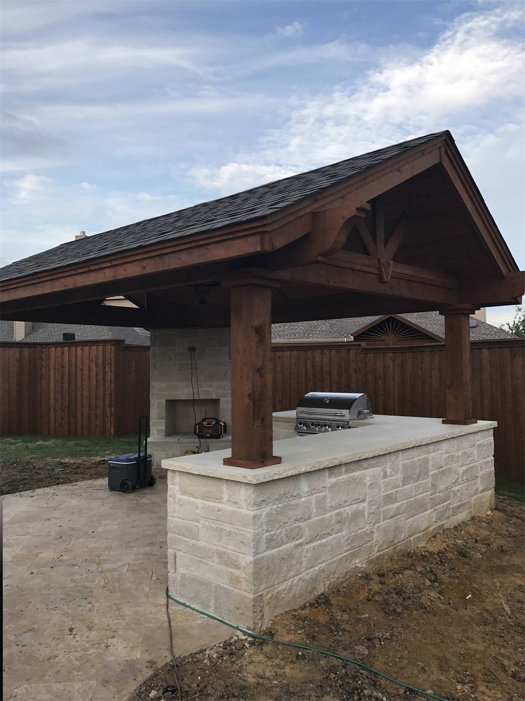 Covered pergola with a stone outdoor kitchen